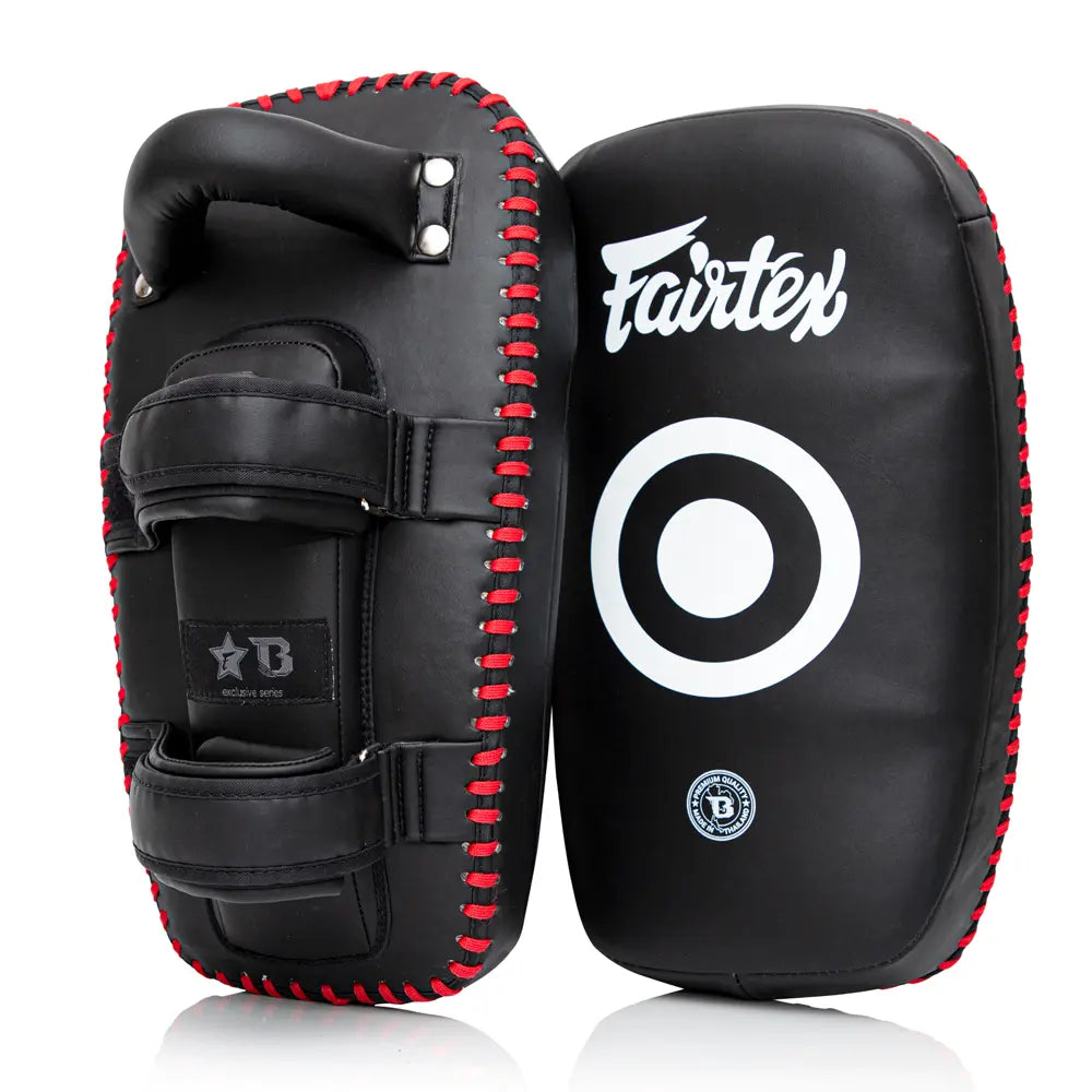 Twee Fairtex Kick Pads Zwart Rood van hoogwaardig leer met witte targetprint aan de voorkant. De pads hebben stevige handgrepen en dubbele klittenbandsluitingen voor maximale controle tijdens intensieve trap- en stoottraining.