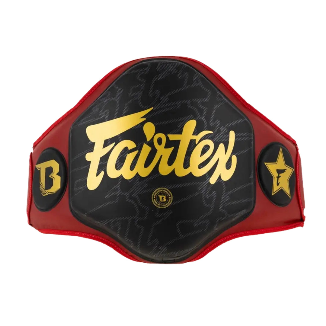 Rood-zwarte Fairtex buikbeschermer met goudkleurig logo en stevige padding aan de voorkant en zijkanten. De brede beschermende vorm maakt de body protector geschikt voor kickboksen, Muay Thai en intensieve trap- en stoottrainingen.