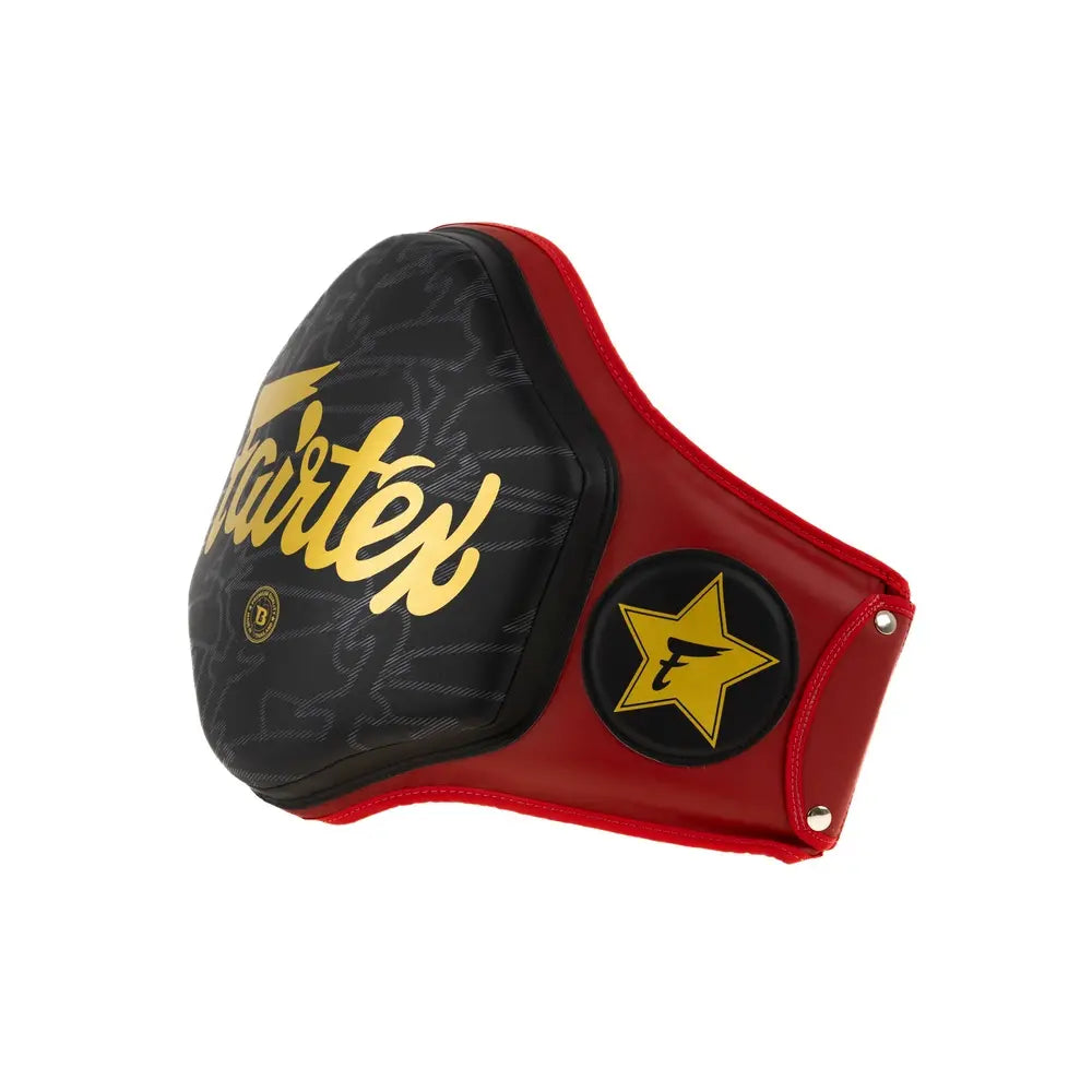 Zijaanzicht van de Fairtex body protector in rood en zwart met gouden logo’s en sterdetail, ontworpen voor maximale impactbescherming tijdens bokstrainingen.