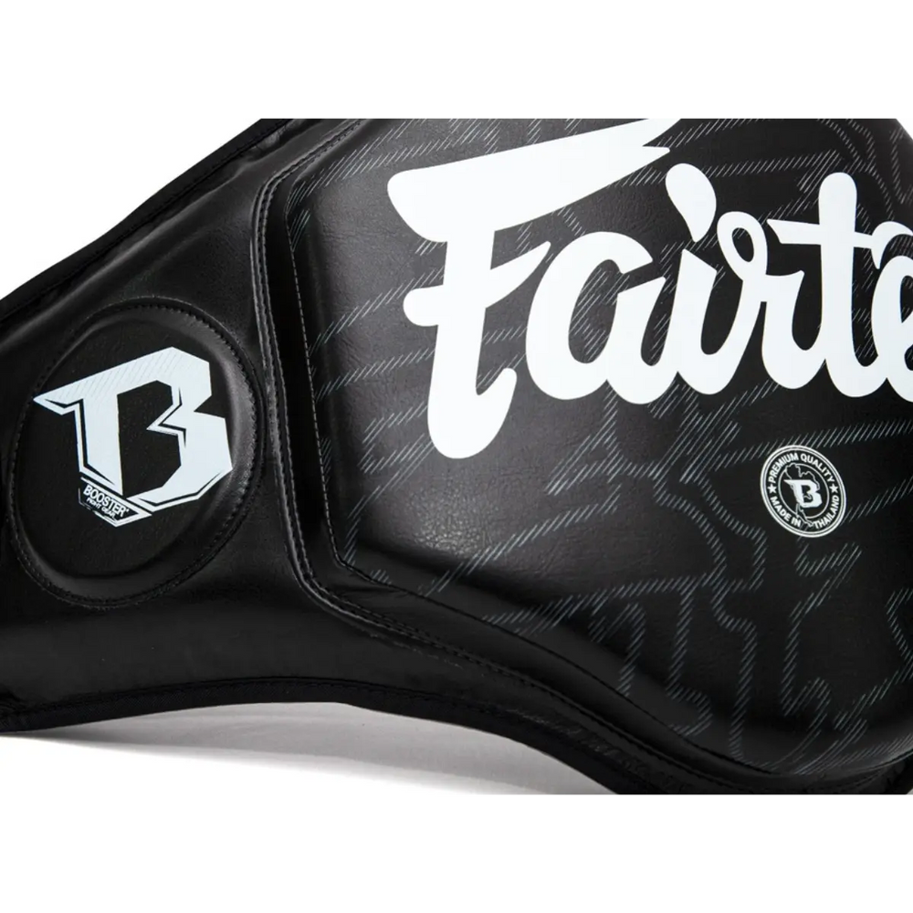 Close-up van een zwarte Fairtex body protector met wit logo en Booster-embleem, gemaakt van hoogwaardig kunstleer voor maximale bescherming tijdens bokstrainingen.