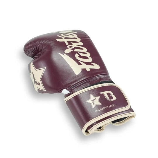 Fairtex bokshandschoen in wijnrode kleur met beige logo’s en Booster-markering, onderdeel van de exclusieve samenwerking tussen Fairtex en Booster voor vechters die stijl en prestaties combineren.
