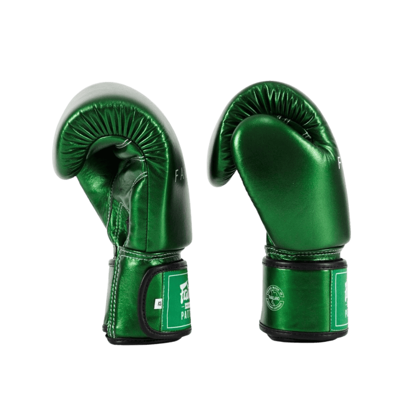 Een zijaanzicht van een paar groene Fairtex-bokshandschoenen, waarbij de gebogen pasvorm en de polssluiting goed zichtbaar zijn.