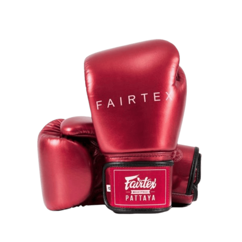 Een paar rode Fairtex bokshandschoenen, waarbij één handschoen rechtop staat en de andere eronder ligt, met het merklogo "Fairtex" duidelijk zichtbaar op de bovenkant