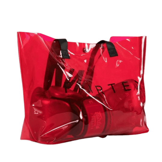 Een paar rode Fairtex bokshandschoenen opgeborgen in een doorzichtige rode tas met zwarte handvatten, en het merk "Fairtex" in zwarte letters op de tas.