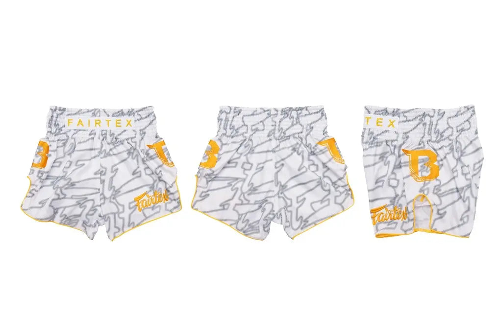 Drie aanzichten van de Fairtex Kickboks Short Wit Geel, met geel logo en grijs patroon. De shorts zijn gemaakt van satijn polyester en ontworpen voor bewegingsvrijheid, comfort en een opvallende stijl tijdens kickbokstrainingen.