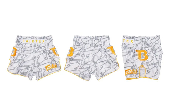 Drie aanzichten van de Fairtex Kickboks Short Wit Geel, met geel logo en grijs patroon. De shorts zijn gemaakt van satijn polyester en ontworpen voor bewegingsvrijheid, comfort en een opvallende stijl tijdens kickbokstrainingen.