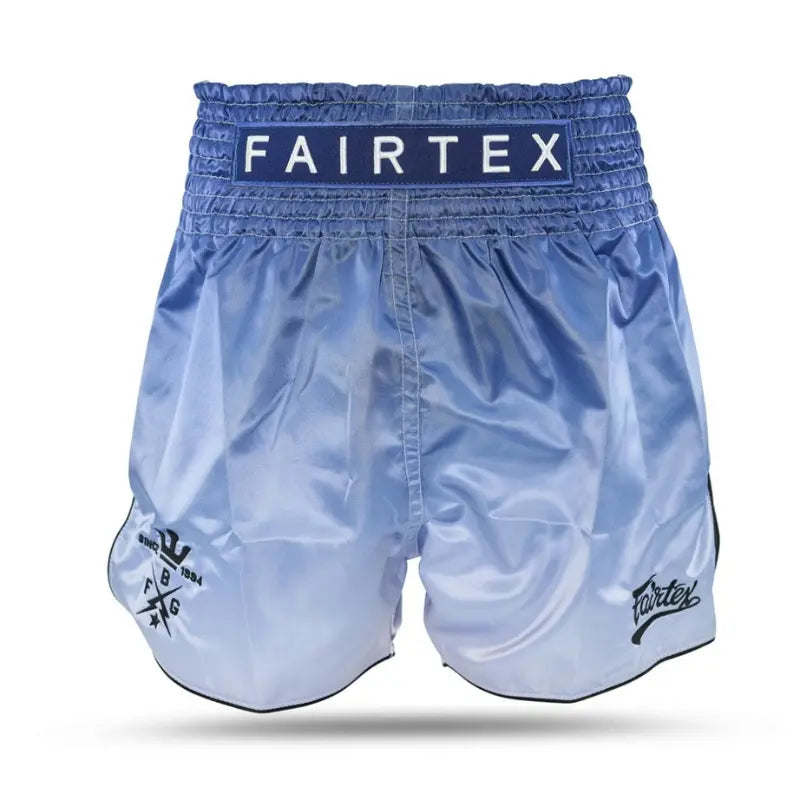 Fairtex kickboks short in lichtblauw satijn, achterzijde met Fairtex-logo op tailleband en kleine zwarte details aan de zijkant.