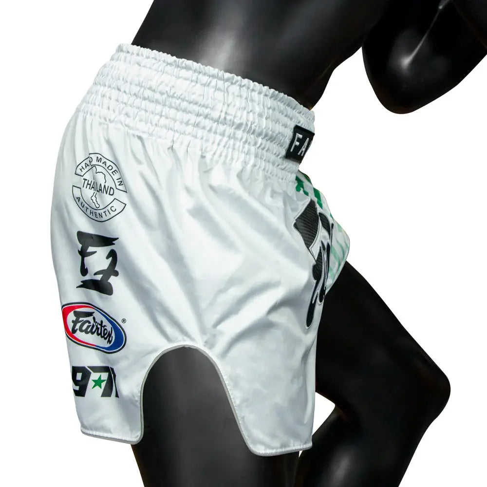 Fairtex Muay Thai shorts in wit met authentieke Thaise opdrukken en elastische tailleband, gedragen door mannequin.