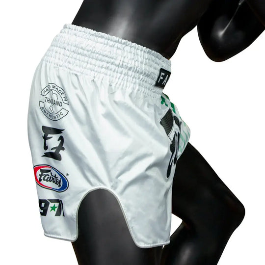 Fairtex Muay Thai shorts in wit met authentieke Thaise opdrukken en elastische tailleband, gedragen door mannequin.