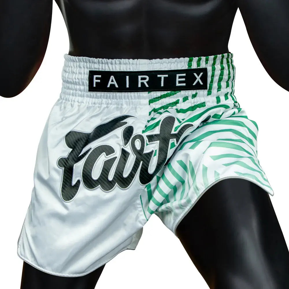 Fairtex Muay Thai shorts in wit met groene strepen en groot Fairtex-logo, gedragen door mannequin.