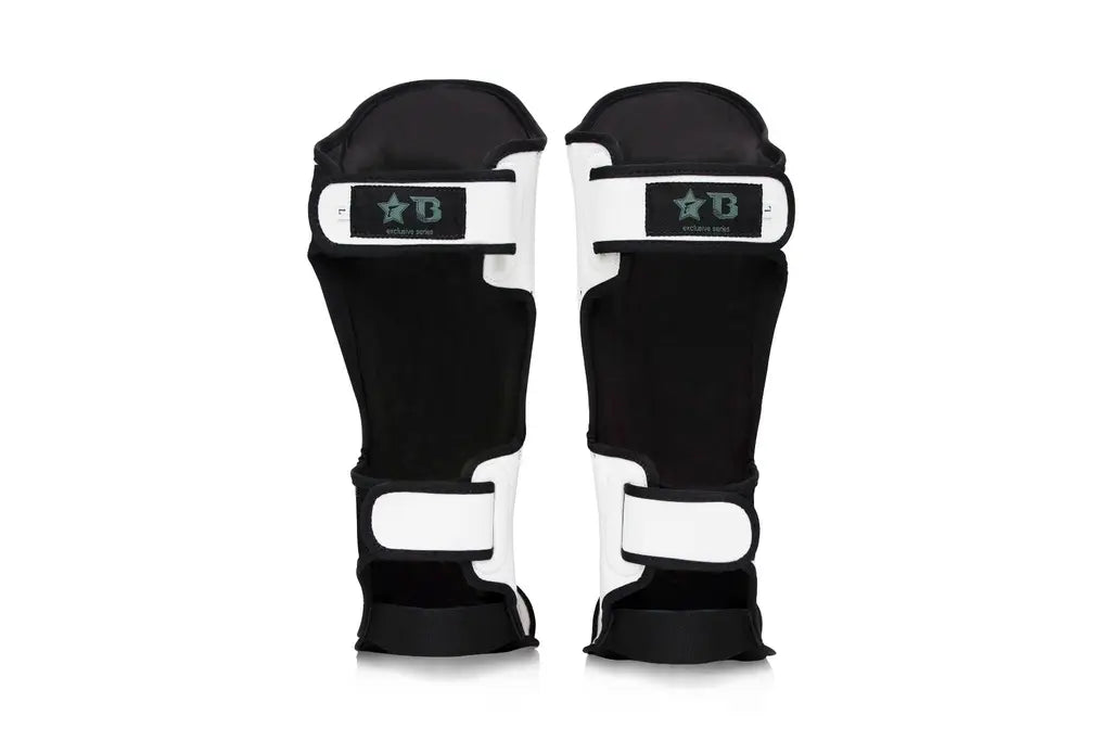 Achterkant van witte Fairtex scheenbeschermers met zwarte binnenvoering en dubbele klittenbandsluiting voor stevige bevestiging en draagcomfort.