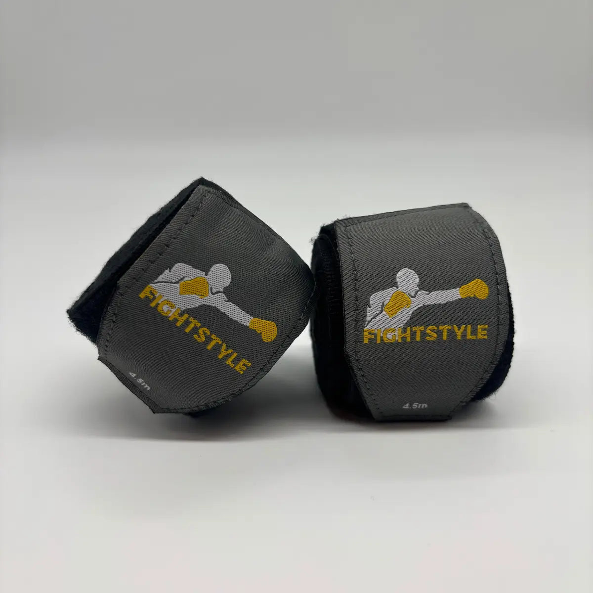 Zwarte Fightstyle bandages van 4.5 meter, deels uitgerold met zichtbaar logo, ideaal voor pols- en knokkelondersteuning tijdens bokstraining.