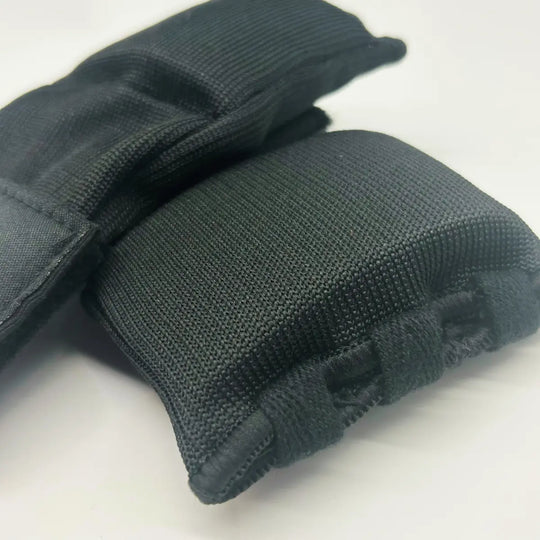 Close-up van zwarte Fightstyle binnenhandschoenen met dikke gebreide knokkelpadding op een witte achtergrond.