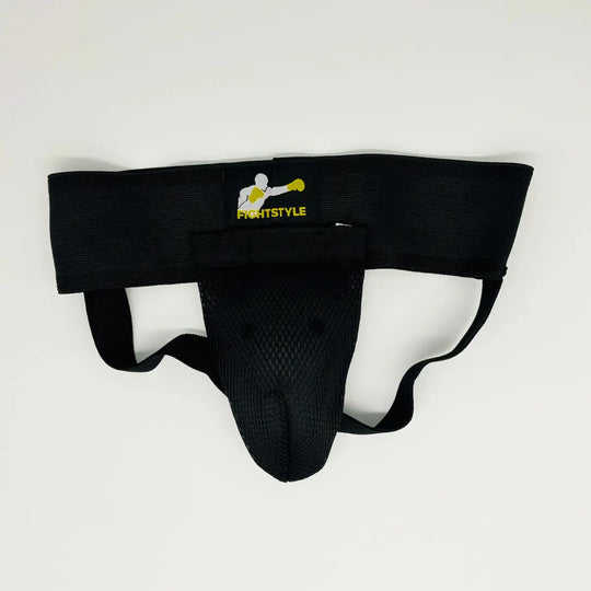 Zwarte Fightstyle kruisbeschermer met brede elastische band, mesh cup en geel Fightstyle-logo op de tailleband.