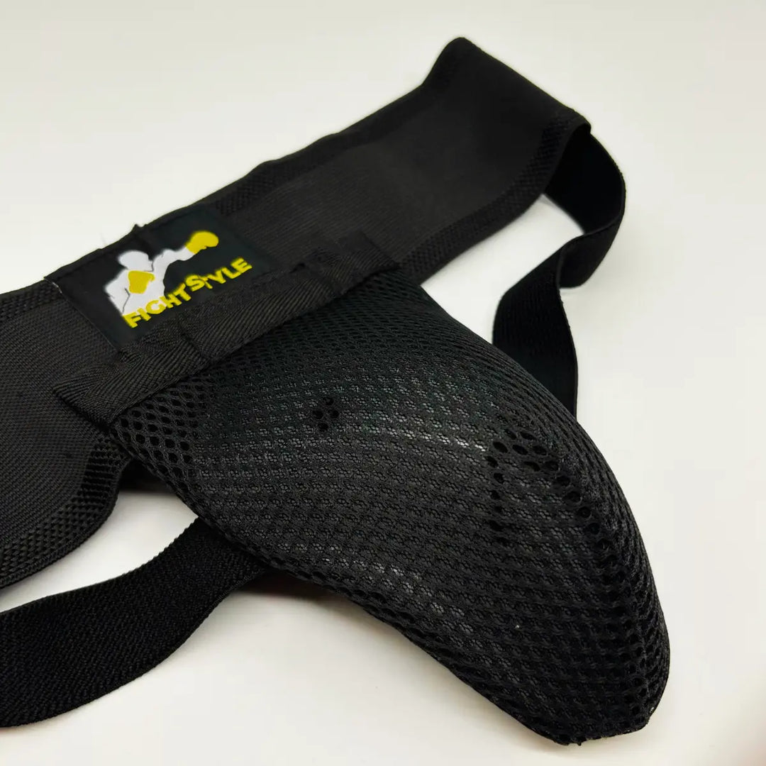 Zwarte Fightstyle kruisbeschermer met geventileerde mesh cup en elastische banden voor stevige bescherming.