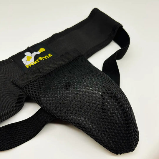 Zwarte Fightstyle kruisbeschermer met geventileerde mesh cup en elastische banden voor stevige bescherming.
