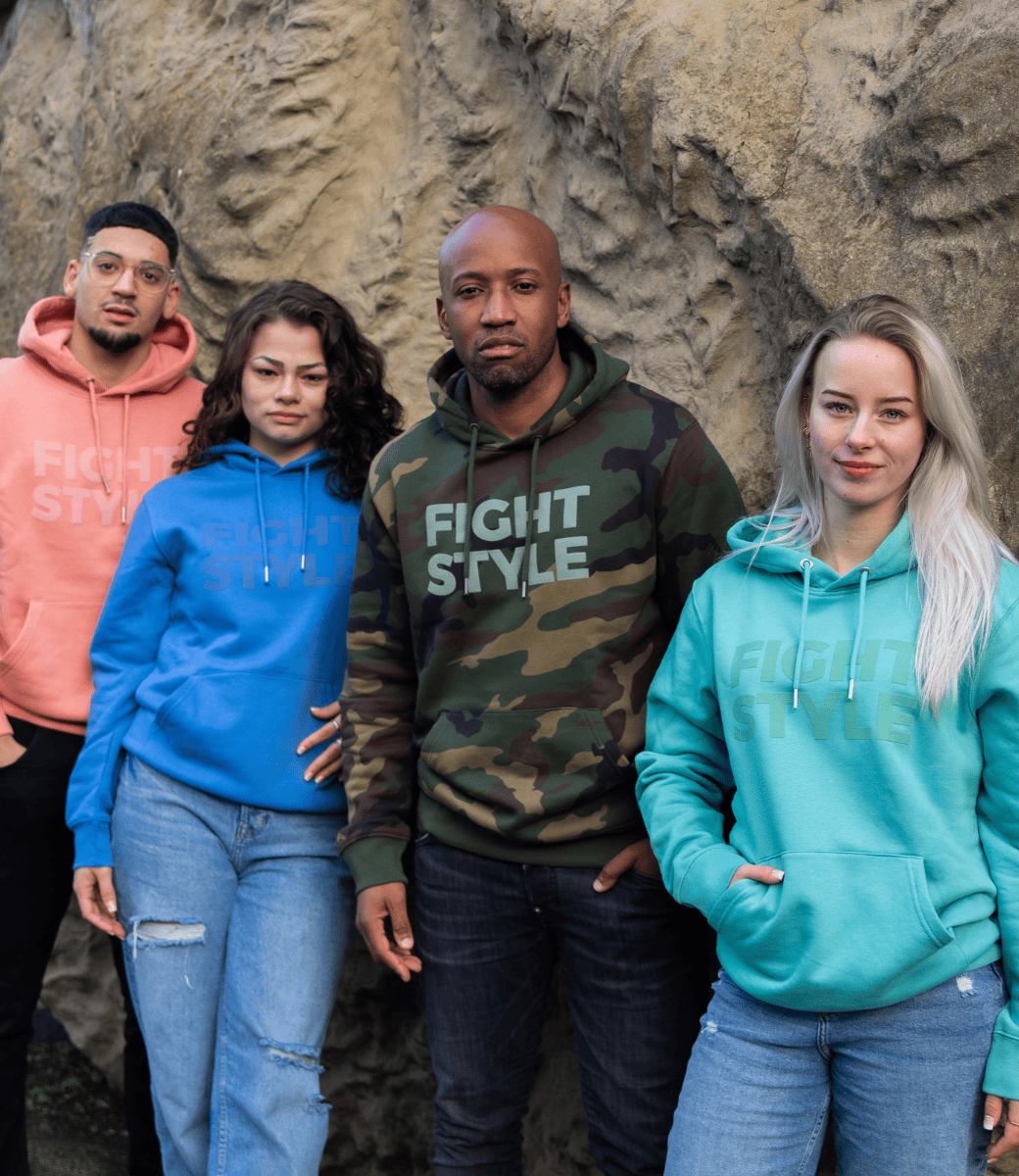 Vier modellen dragen verschillende Fightstyle hoodies voor een rotswand: in camouflagegroen, aqua, blauw en peach. De hoodies hebben een sportieve pasvorm, zachte fleecevoering en een minimalistisch logo op de borst — ideaal voor comfort en stijl buiten de gym.
