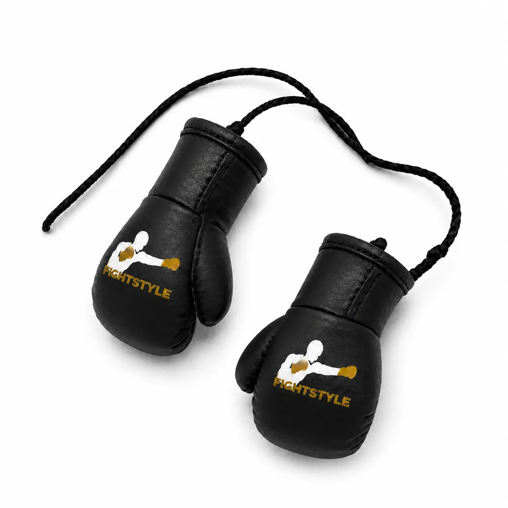 Zwarte mini bokshandschoenen van Fightstyle met geel-wit logo en ophangkoord. Het compacte ontwerp maakt ze geschikt als decoratie, accessoire of sportieve toevoeging voor boksers en kickboksers.