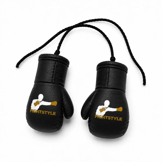 Zwarte mini bokshandschoenen van Fightstyle met geel-wit logo en zwart ophangkoord. Het compacte ontwerp maakt ze geschikt als decoratie, accessoire of sportieve toevoeging voor boksers en kickboksers.