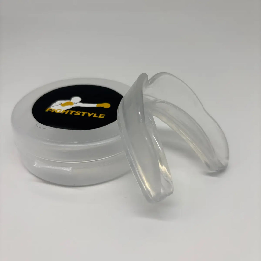 Close-up van de transparante Fightstyle mondbeschermer met bijbehorend opbergdoosje, bedoeld voor bescherming tijdens bokstraining.