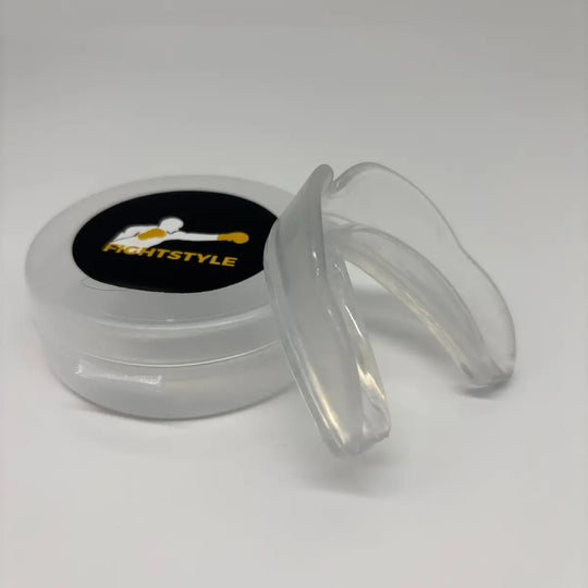 Close-up van de transparante Fightstyle mondbeschermer met bijbehorend opbergdoosje, bedoeld voor bescherming tijdens bokstraining.