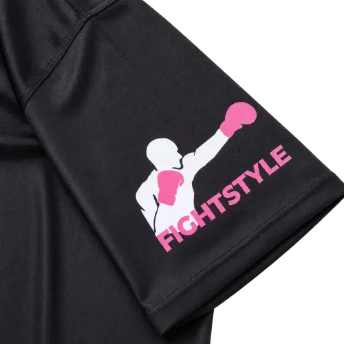 Close-up van een zwart sportshirt met roze Fightstyle logo op de mouw. De gladde sportstof en strakke afwerking maken het shirt geschikt voor boksen, kickboksen, MMA en intensieve trainingen.
