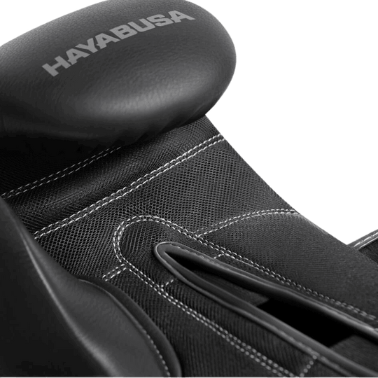 Close-up van de bovenkant van een Hayabusa Bokshandschoen, waarbij de textuur van het zwarte leer en de fijne stiksels zichtbaar zijn.