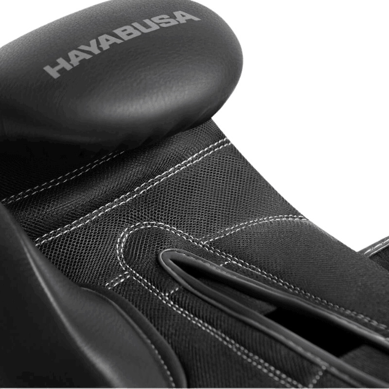 Close-up van de bovenkant van een Hayabusa Bokshandschoen, waarbij de textuur van het zwarte leer en de fijne stiksels zichtbaar zijn.