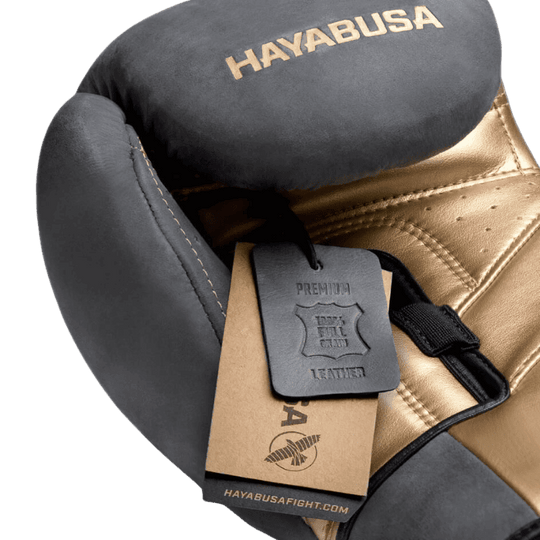 Close-up van de Hayabusa T3 LX Obsidian bokshandschoen die het kwaliteitslabel toont met de tekst "PREMIUM FULL GRAIN LEATHER".