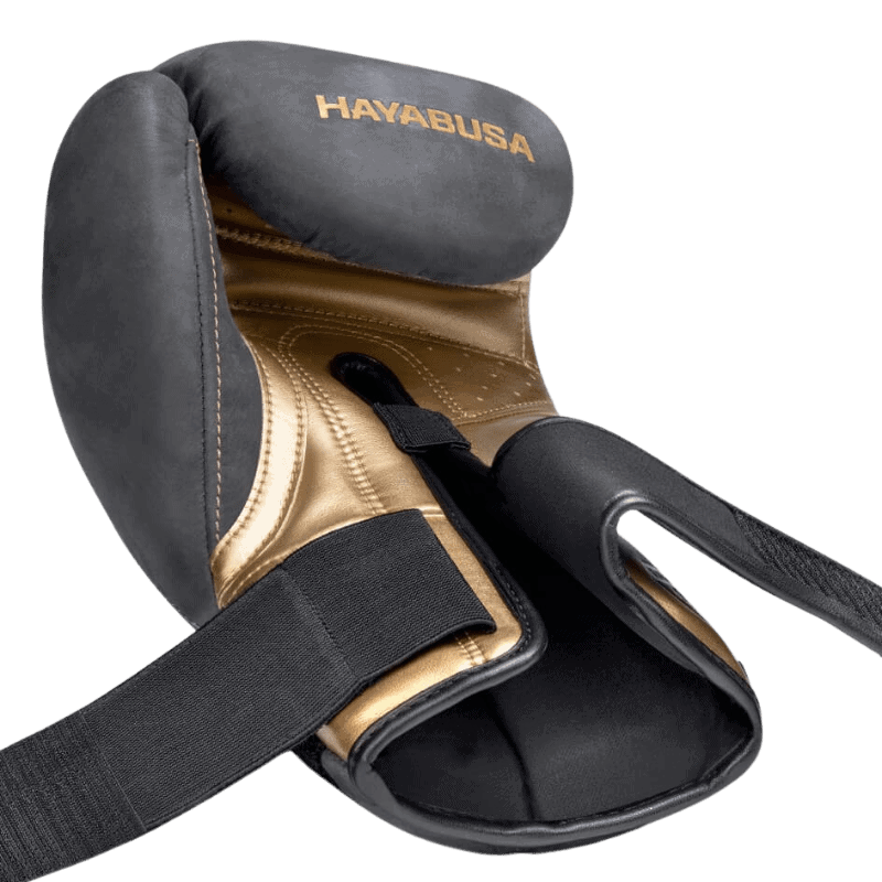 Een gedetailleerde weergave van de binnenkant van een Hayabusa T3 LX Obsidian bokshandschoen met een gouden afwerking en zwarte buitenkant.
