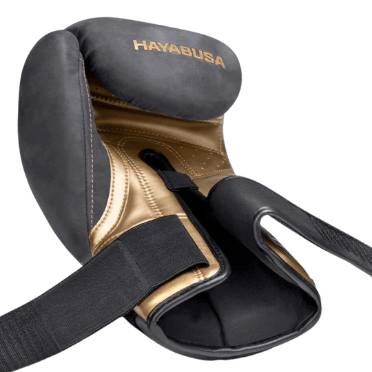 Een gedetailleerde weergave van de binnenkant van een Hayabusa T3 LX Obsidian bokshandschoen met een gouden afwerking en zwarte buitenkant.