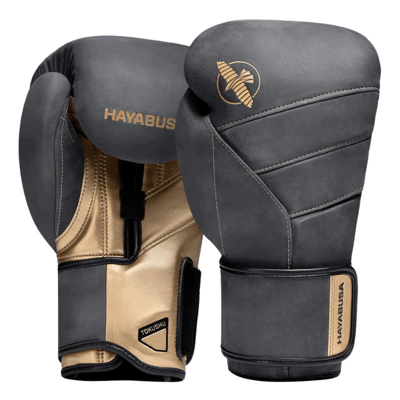 Een paar Hayabusa T3 LX Obsidian bokshandschoenen met gouden accenten op de bovenkant, waarbij één handschoen de klittenbandsluiting toont en de ander de gevoerde rug.