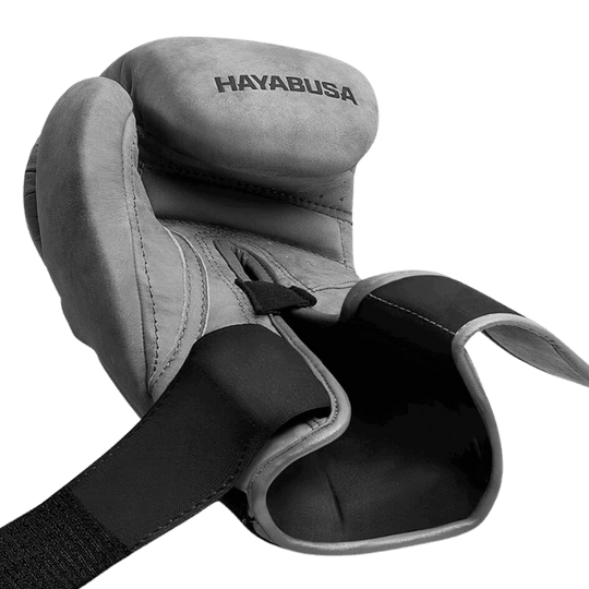 Close-up van een Hayabusa T3 LX Slate bokshandschoen met het klittenband halfopen, getoond in zwart-wit voor een sterke focus op de textuur.