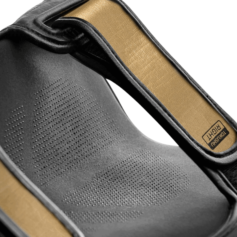 Detailopname van de binnenkant van een Hayabusa T3 Striking Scheenbeschermer in zwart en goud, waarbij het ademende materiaal en de voering benadrukt worden.