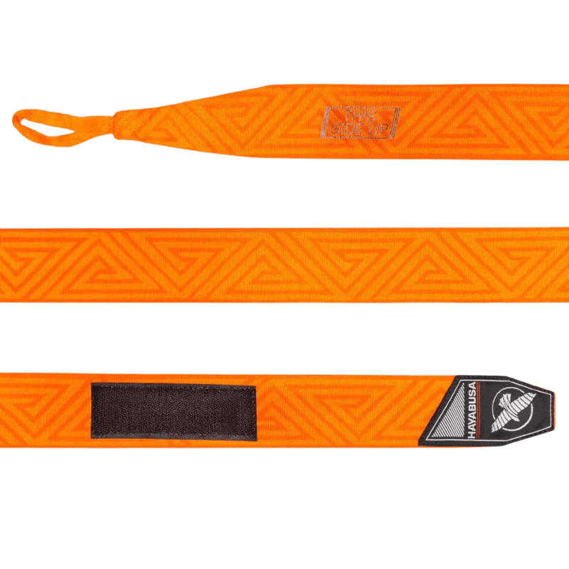 Een volledig uitgestrekte Hayabusa Perfect Stretch Bandage in oranje, met het doolhofpatroon over de lengte en 'THIS SIDE UP' instructie aan het ene uiteinde en een zwart klittenbandstuk aan het andere, naast het logo.