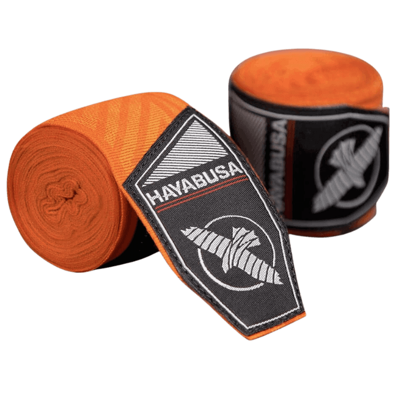 Een paar Hayabusa Perfect Stretch Bandages in de kleur oranje met een ingewikkeld doolhofpatroon, opgerold naast hun zwarte verpakking met het Hayabusa valk-logo in wit.