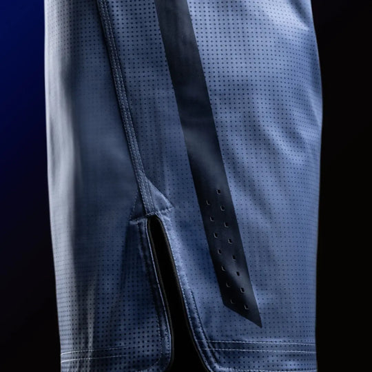 Detail van de zijsplit met mesh inzet voor extra bewegingsvrijheid.