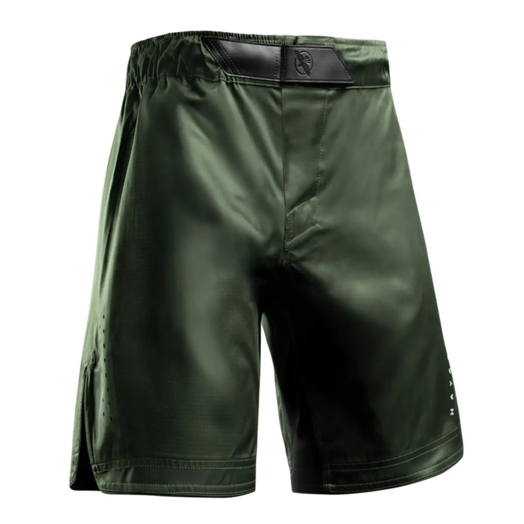 Vooraanzicht van groene fight shorts met elastische tailleband en zwart accent bij het kruis.