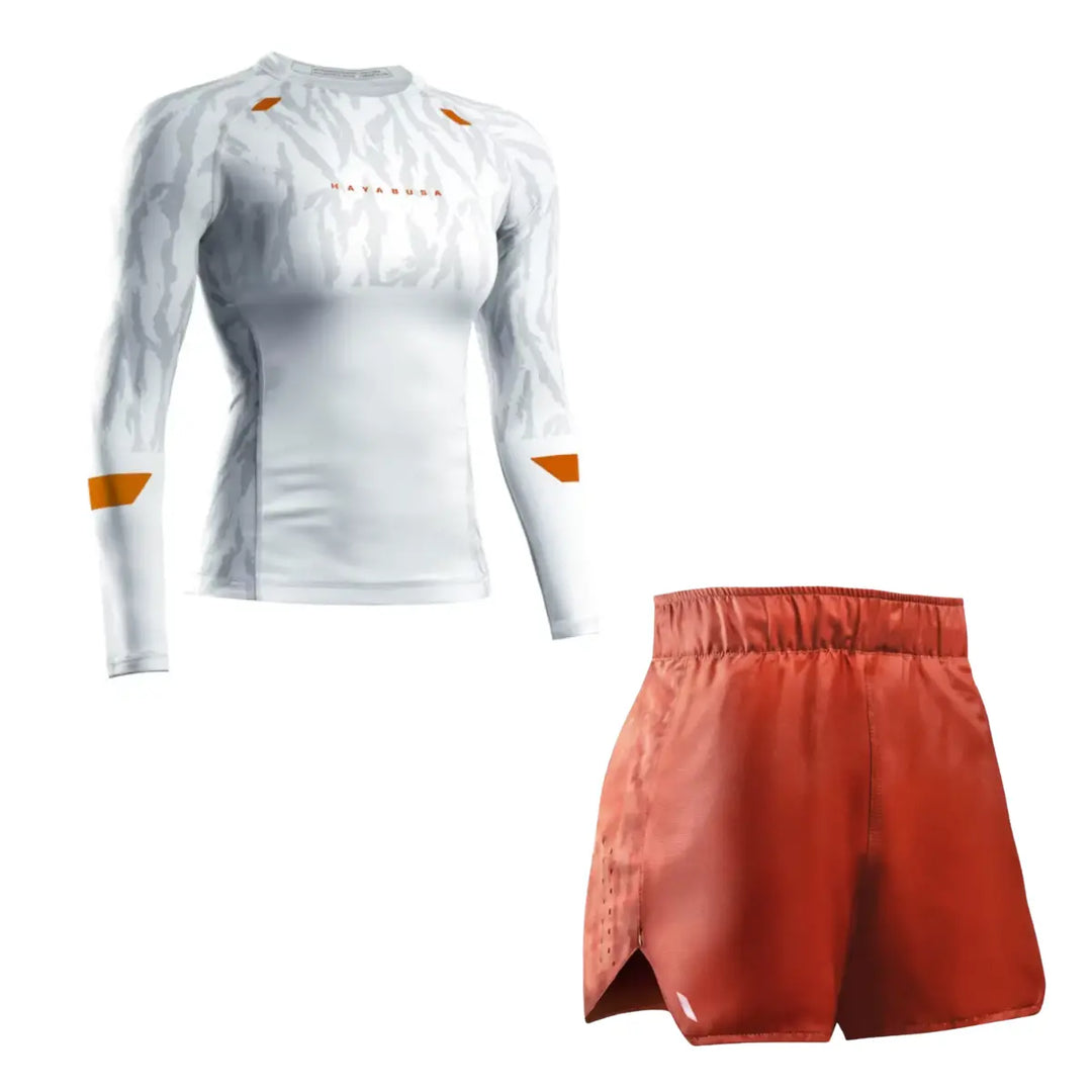 Hayabusa Apex training set consisting of a white long sleeve rash guard and red training shorts, shown side by side. The rash guard features a subtle camo pattern with orange accents and a compression fit, while the shorts have a lightweight design with an elastic waistband and side slits for unrestricted movement during training.