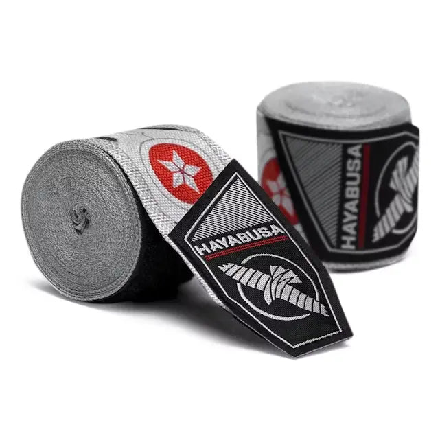 Grijze Hayabusa handwraps met rood-wit Falcon ster logo en zwart Hayabusa label, netjes opgerold en gepresenteerd.