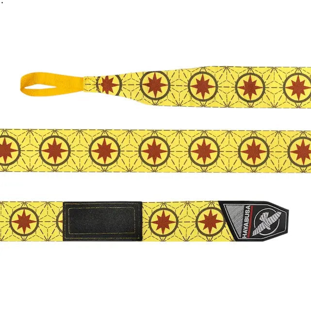 Op deze afbeelding zie je de Hayabusa Marvel Captain Marvel Handwraps volledig uitgestrekt. Het design is helder geel met herhalende rode sterren in cirkels en een subtiel lijnpatroon. Aan het uiteinde is de Hayabusa-klittenbandsluiting goed zichtbaar.