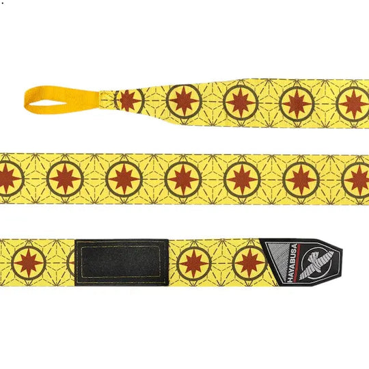 Op deze afbeelding zie je de Hayabusa Marvel Captain Marvel Handwraps volledig uitgestrekt. Het design is helder geel met herhalende rode sterren in cirkels en een subtiel lijnpatroon. Aan het uiteinde is de Hayabusa-klittenbandsluiting goed zichtbaar.