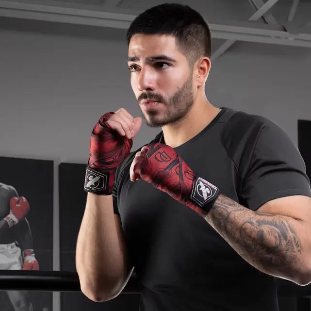 Man in zwarte sportkleding staat in gevechtshouding met rode Hayabusa handwraps uit de Marvel Daredevil-collectie.