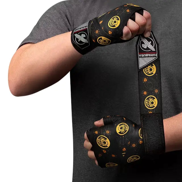 Persoon die zwarte Hayabusa Thanos bandages met gele Infinity Gauntlet symbolen en Infinity Stones om zijn handen wikkelt, zichtbare Hayabusa-logo’s op de pols.