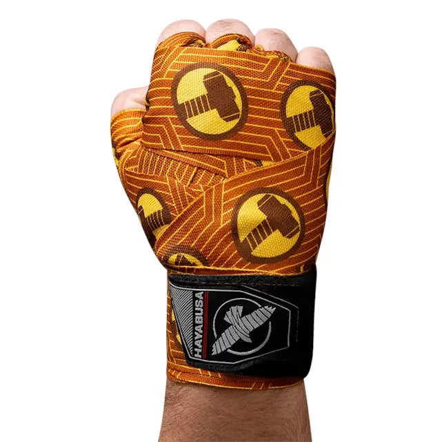 Hayabusa bandages met Thor-hamer print om een vuist gewikkeld, oranje-geel design met zwarte polsband en Hayabusa logo.