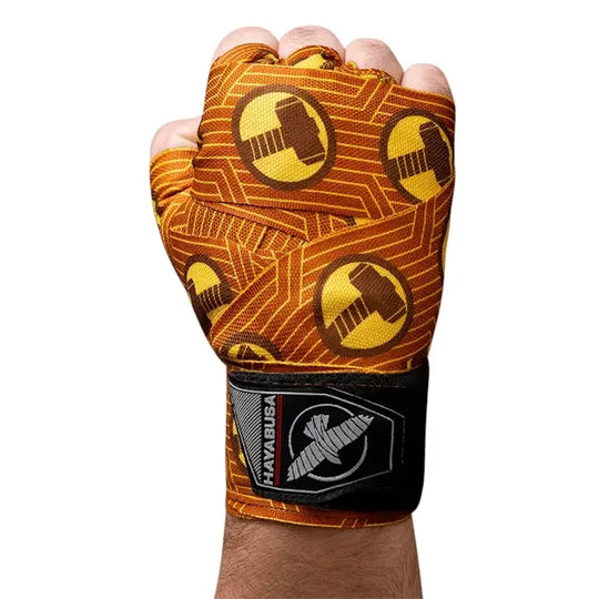 Hayabusa bandages met Thor-hamer print om een vuist gewikkeld, oranje-geel design met zwarte polsband en Hayabusa logo.