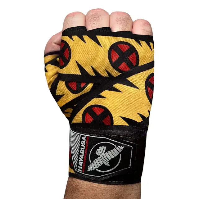 Hand in vuistpositie gewikkeld in Hayabusa Wolverine bandage met geel-zwart design en rode X-Men logo’s, zichtbaar polslabel.