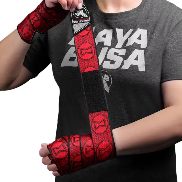 Persoon wikkelt rode Hayabusa Black Widow handwraps om pols en hand