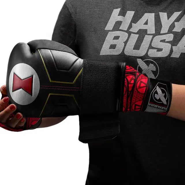 Hand in zwart-rode Hayabusa Black Widow bokshandschoen met bijpassende rode Black Widow handwraps