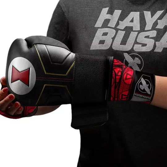 Hand in zwart-rode Hayabusa Black Widow bokshandschoen met bijpassende rode Black Widow handwraps